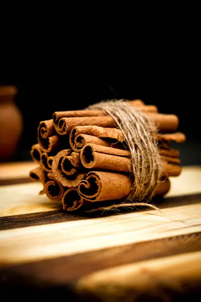 Tarçın çubuklarının yakın plan görüntüsü, zengin dokusunu ve doğal cazibesini vurguluyor. Mutfak içeriği, ev dekorasyonu ve mevsimlik promosyonlar için mükemmel.