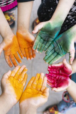 Sanatçı paletine benzeyen Holi renkleriyle lekelenmiş ellerin yaratıcı bir bileşimi. Sanat için ideal