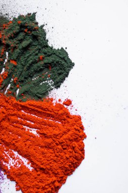 Holi festivalinin turuncu ve yeşil renkleri beyaz arka planda, kutlamanın enerjisini ve canlılığını yansıtıyor. Hint bayrağı ilham kaynağı