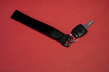 Modern black fabric keyholder mockup on a red background, perfect for product displays and advertising.