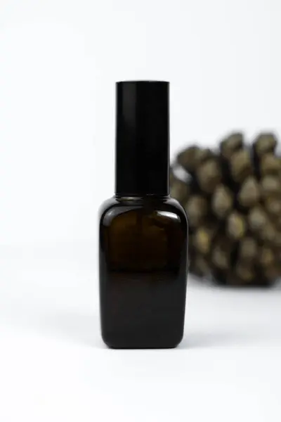 A sleek black glass hair serum bottle isolated on a clean white background. Perfect for haircare product displays and branding.