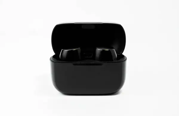 Beyaz arka planda kablosuz kulaklıklar ve şarj çantası, teknoloji ürünleri ve markalar için harika..
