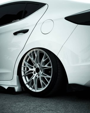 Pürüzsüz gümüş alaşımlı jantları olan göz kamaştırıcı beyaz bir araba, temiz bir arka planda izole edilmiş. Üst düzey otomotiv tasarımı ve lüks araç markalaşması için mükemmel..