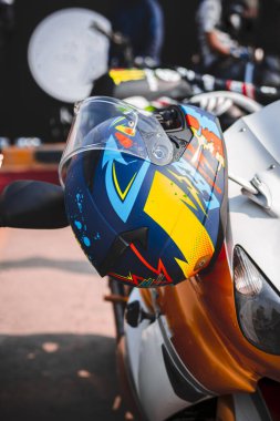 Ağır bir bisiklet sapında asılı renkli motosiklet kaskları, gösteriş tarzı ve macera. Bisiklet meraklıları, motosiklet markaları ve spor fotoğrafçılığı için mükemmel..