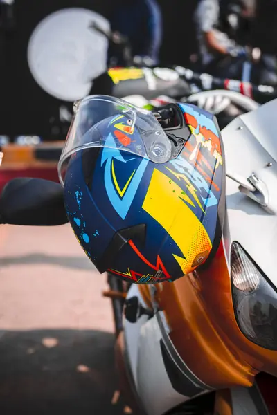 Ağır bir bisiklet sapında asılı renkli motosiklet kaskları, gösteriş tarzı ve macera. Bisiklet meraklıları, motosiklet markaları ve spor fotoğrafçılığı için mükemmel..