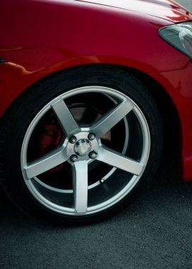 Zarif alaşımlı kenarı olan göz kamaştırıcı kırmızı lüks bir araba tekerleği. Zarafet ve incelik sergiliyor. Lüks otomotiv markaları ve prim reklamları için mükemmel.