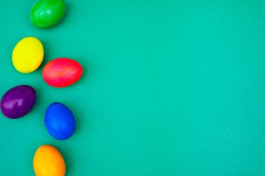 Mavi Arkaplanda Paskalya Yumurtaları. Yaratıcı Paskalya tanıtımları ve web içeriği için mavi arka planda renkli yumurtaların eğlenceli ve şenlikli düzenlenmesi