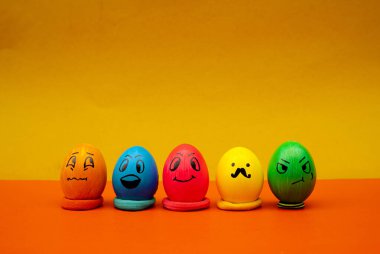 Parlak renkli emoji yumurtaları neşeli ve neşeli bir Paskalya fotoğrafı için sıraya dizildi. Eğlenceli ifadeli yaratıcı Paskalya Yumurtası Yüzleri