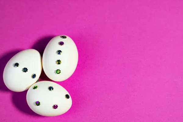 Mor kağıda yerleştirilmiş Paskalya yumurtalarının parlak ve neşeli fotoğrafı mevsimsel eğlence ve yaratıcılığı temsil ediyor..
