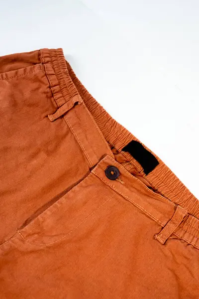 Şık giyinmek için turuncu günlük pantolonların detaylarını gösteren yakın çekim..
