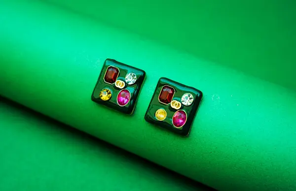 Moda Ekranı için Yeşil Arkaplan ile yakın plan küpeler, çıtır yeşil ayara karşı yüksek çözünürlüklü küpeler, eCommerce kullanımı için mükemmel.