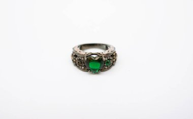 Yeşil zümrüt değerli bir taşa sahip lüks bir yüzük, beyaz bir arka planda izole edilmiş, üst düzey ve moda temalı kullanım için mükemmel..