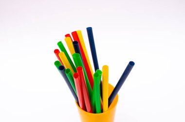 Tekrar kullanılabilen renkli pipetler, beyaz stüdyo yüzeyinde izole bir şekilde bir konteynırın içinde dikiliyordu..
