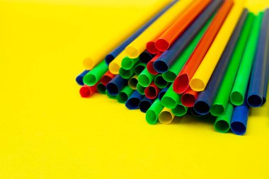 Sarı temalı ortamda izole edilmiş renkli pipetler, yiyecek veya içecek reklamları için ideal.
