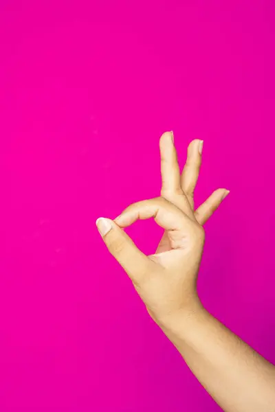  Alış veriş simgeleri, ürün görselleri veya mobil aygıtlar yerleştirmek için negatif alan bırakarak bir jest oluşturan bir insan elinin iyi aydınlatılmış bir görüntüsü.