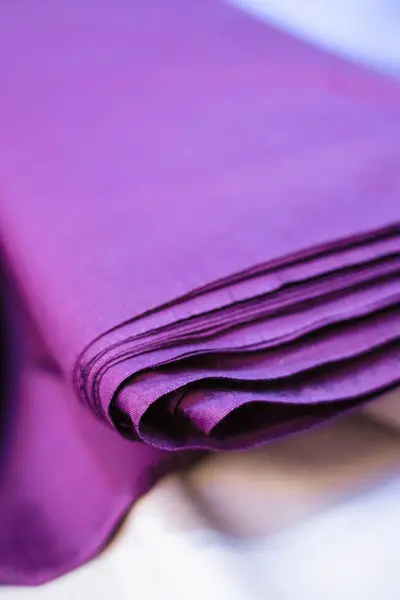 Lüks mor bir kumaşın yakın çekim görüntüsü zengin dokusunu ve derin rengini gözler önüne seriyor. Sofistike ve zarif bir arkaplan gerektiren tasarım projeleri için ideal.