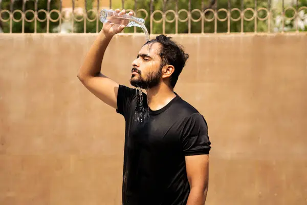 Siyah tişörtlü bir adam sıcak bir günde kafasının üstüne güneş yanığı duvarına su döker. Yüzünden ve gömleğinden su damlacıkları akıyor. Sahne, fiziksel aktivite sonrası ısı ve yorgunluktan kurtulmayı öneriyor..