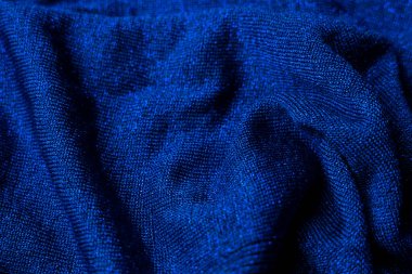 Dramatik bir yakın plan, koyu mavi kumaşın zengin dokusunu gözler önüne seriyor. Yumuşak kıvrımlar ve ince titreşimler lüks ve zarif bir görüntü yaratır. Karmaşık örgü deseni görünür, olay yerine derinlik ve ilgi ekler.