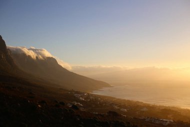 Cape Town sahilindeki dağlarda bulutların üzerinde inanılmaz bir günbatımı. Seçici odak