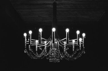 black and white film photo of chandelier with illumination
