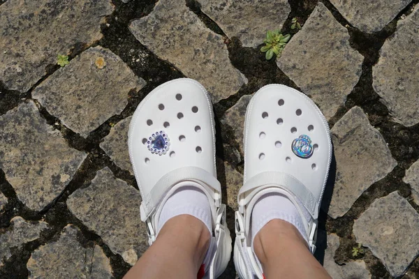 Kaki Wanita Memakai Sepatu Crocs Putih Kaki Lantai Batu — Stok Foto
