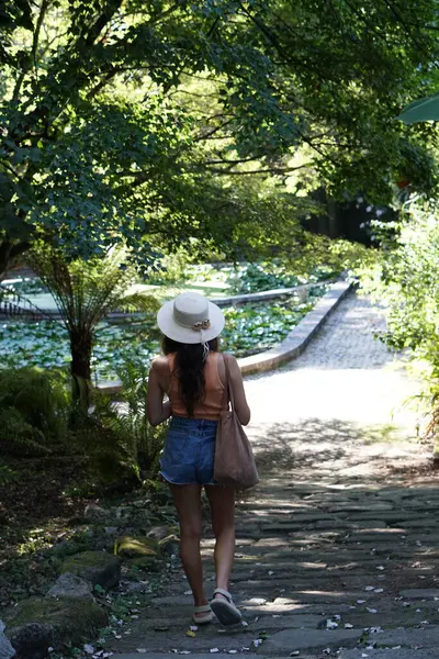 Frau Mit Sommermütze Botanischen Garten Mit Bäumen Sommerliche Natur lizenzfreie Stockfotos