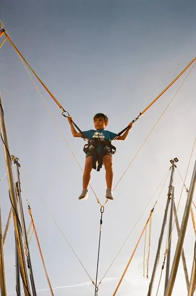 Junge Springt Mit Seil Blauen Himmel lizenzfreie Stockbilder