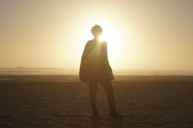 Gün batımında sahilde beyaz bir kadın. 