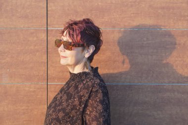 Gün batımında plajda orta yaşlı beyaz bir kadın. 