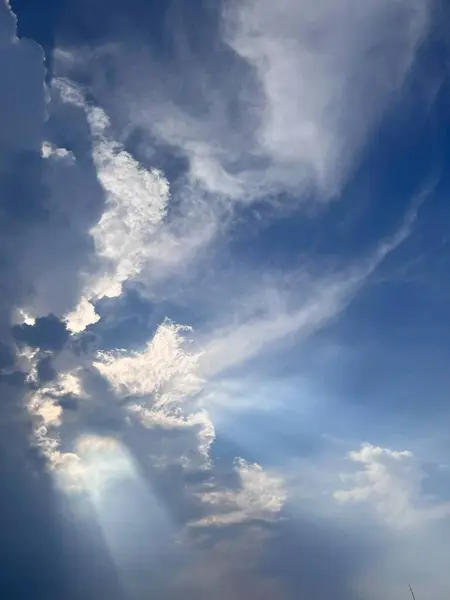 Karanlık bulutların parlak gün ışığında çekilmiş fotoğrafı, arkalarından gelen güneş ışığı, arka plan ve duvar kağıtları için uygundur.