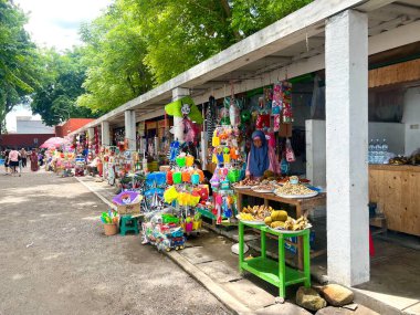 Surabaya, Endonezya - 25 Şubat 2025: Gündüz Surabaya 'daki Kenjeran plajında yiyecek ve çocuk oyunları satan dükkanlar