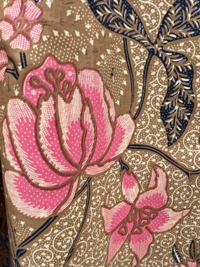 Batik kumaşın güzelliğinin dikey fotoğrafı. Çiçek ve yaprakların karmaşık motifleri. Geleneksel Batik 'teki desenler, görsel ve felsefi güzelliği temsil ediyor.