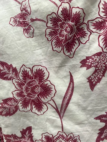 Batik kumaşın güzelliğinin dikey fotoğrafı. Çiçek ve yaprakların karmaşık motifleri. Geleneksel Batik 'teki desenler, görsel ve felsefi güzelliği temsil ediyor.