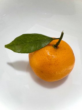 Tatlı bir tadı olan ve beyaz arka planda izole edilmiş C vitamini açısından zengin bir shantang portakalının dikey fotoğrafı.