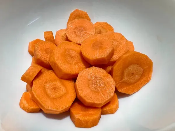 İnce dilimlenmiş havuçların yatay fotoğrafı, beyaz arka planda izole edilmiş.