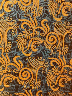 Kahverengi arka planda soyut motiflerle geleneksel Endonezya batik kumaşının güzelliğinin dikey fotoğrafı.