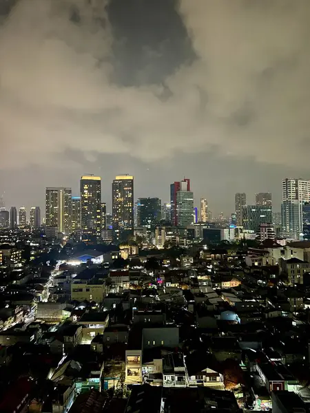 Jakarta 'nın merkezindeki atmosfer, Kuningan bölgesi. Binaların ve motorlu taşıtların ışıklarıyla aydınlatılan gökyüzünün arka planında