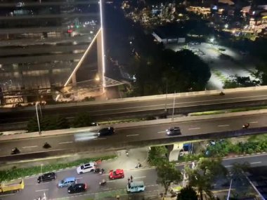 Hem şehir içi otoyol hem de ofislerin yakınındaki trafik atmosferi yoğun ve pürüzsüz, geceleri Endonezya 'nın Jakarta kentindeki Kuningan bölgesinde yer alıyor..