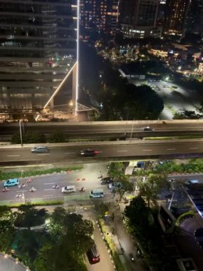 Hem şehir içi otoyol hem de ofislerin yakınındaki trafik atmosferi yoğun ve pürüzsüz, geceleri Endonezya 'nın Jakarta kentindeki Kuningan bölgesinde yer alıyor..