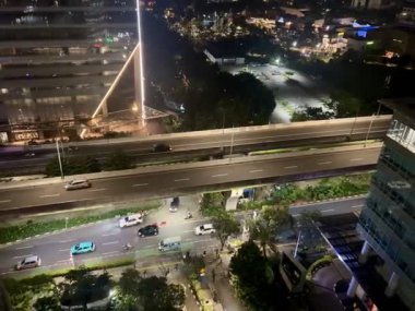 Hem şehir içi otoyol hem de ofislerin yakınındaki trafik atmosferi yoğun ve pürüzsüz, geceleri Endonezya 'nın Jakarta kentindeki Kuningan bölgesinde yer alıyor..