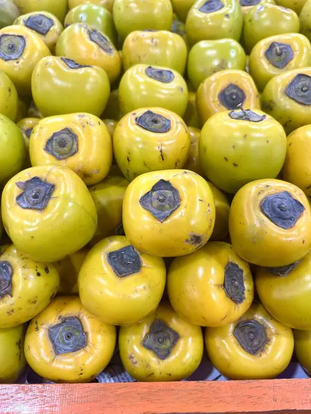 Meyve dükkanında sergilenen bir yığın olgun hurma. Bu fotoğraf kitap kapakları, dergiler, gazeteler, reklamlar, afişler, afişler ve sosyal medya paylaşımları için uygundur..