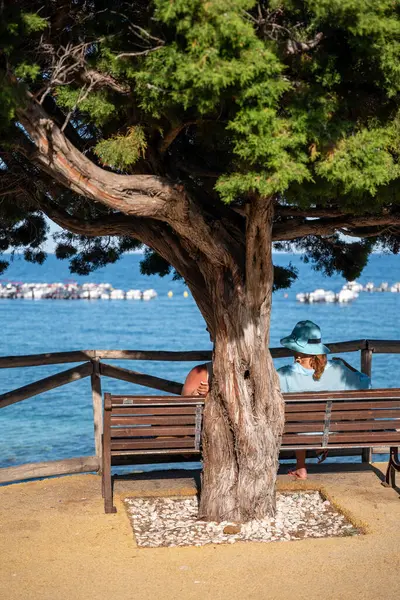 Sardunya 'da bir bankta oturan insanlar