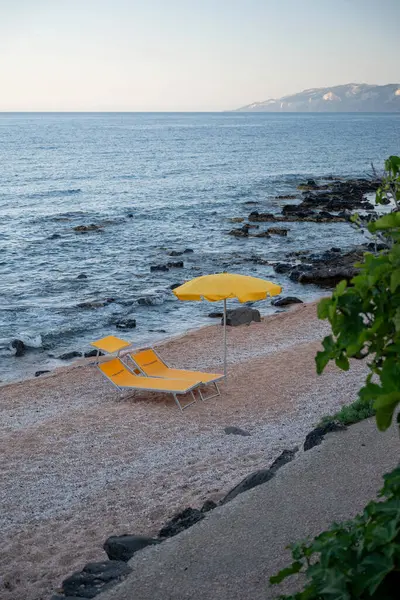 Akşamları Cala Gonone 'da sarı şemsiyeli bir plaj.