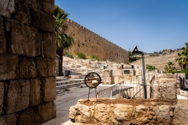 Antik taş duvar ve temiz mavi gökyüzünün altında taş basamakları olan arkeolojik kalıntılar. Tarih, arkeoloji veya seyahat teması için ideal.