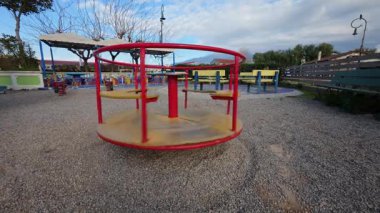 Gün batımında, kırık bir oyuncak yalnızlık ve gizemle dolu boş oyun bahçesinde ürkütücü bir şekilde hareket eder..