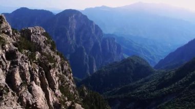 Çarpıcı insansız hava aracı görüntüsü ufuk boyunca uzanan kayalık dağların geniş bir görüntüsünü ortaya çıkarıyor..