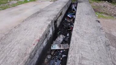 Giysiler, plastikler ve yağlar da dahil olmak üzere atılmış atık, çevreyi kirletiyor, kirliliği giderme ve doğayı koruma ihtiyacını gösteriyor.