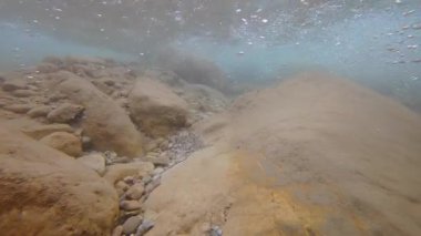 Akan bir nehirde, kayalık derinliklerden nefes kesici bir dağ zeminine geçiş görüntüsü..