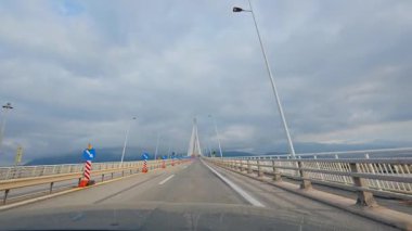 Gökyüzü bulutluyken Yunanistan 'daki Rio Antirrio köprüsünden geçmek.