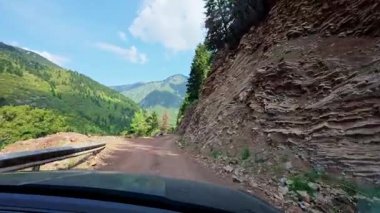 Offroad aracı gün ışığında engebeli dağ arazisinde seyahat eder..